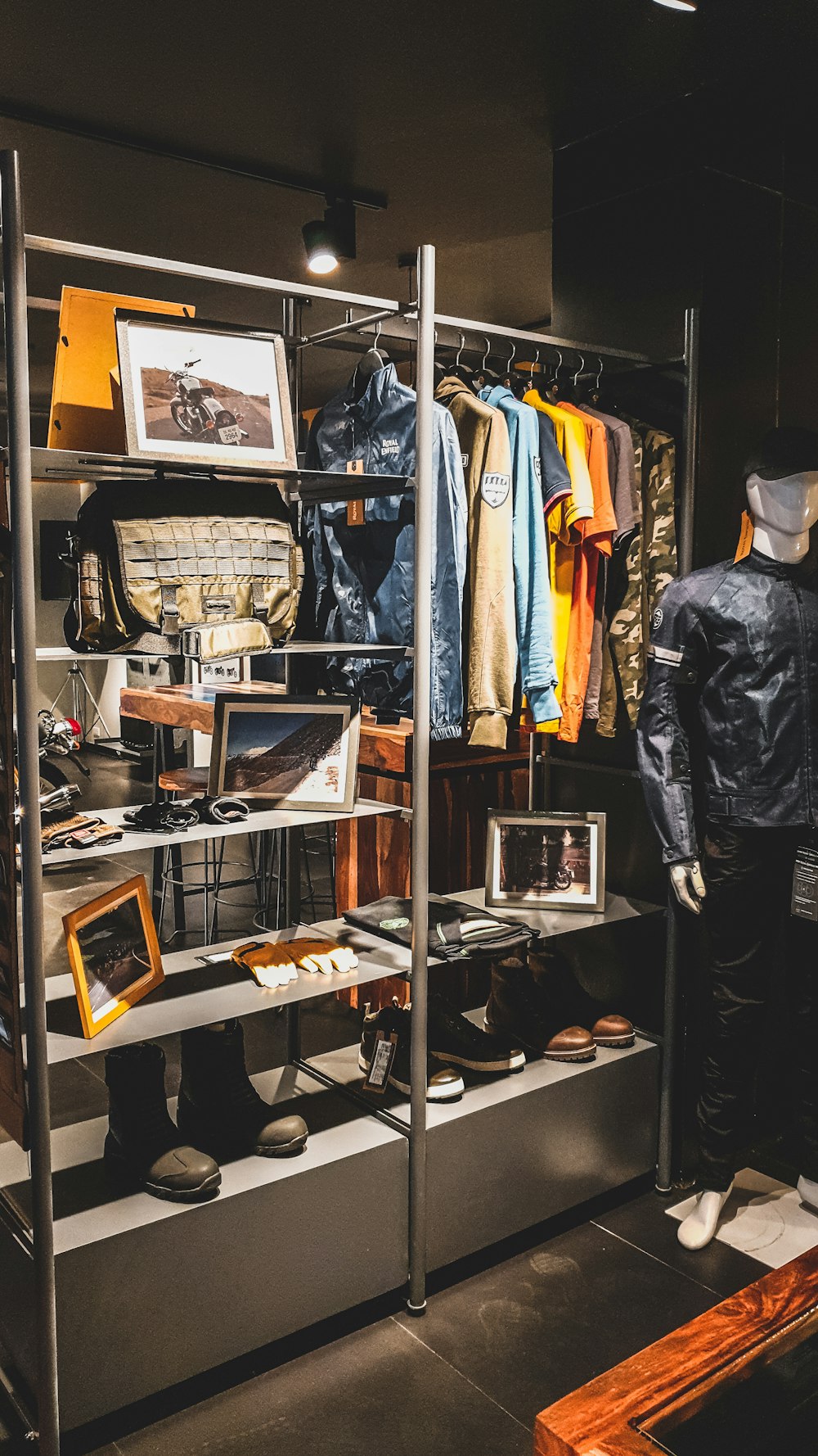 man in black leather jacket standing near clothes rack