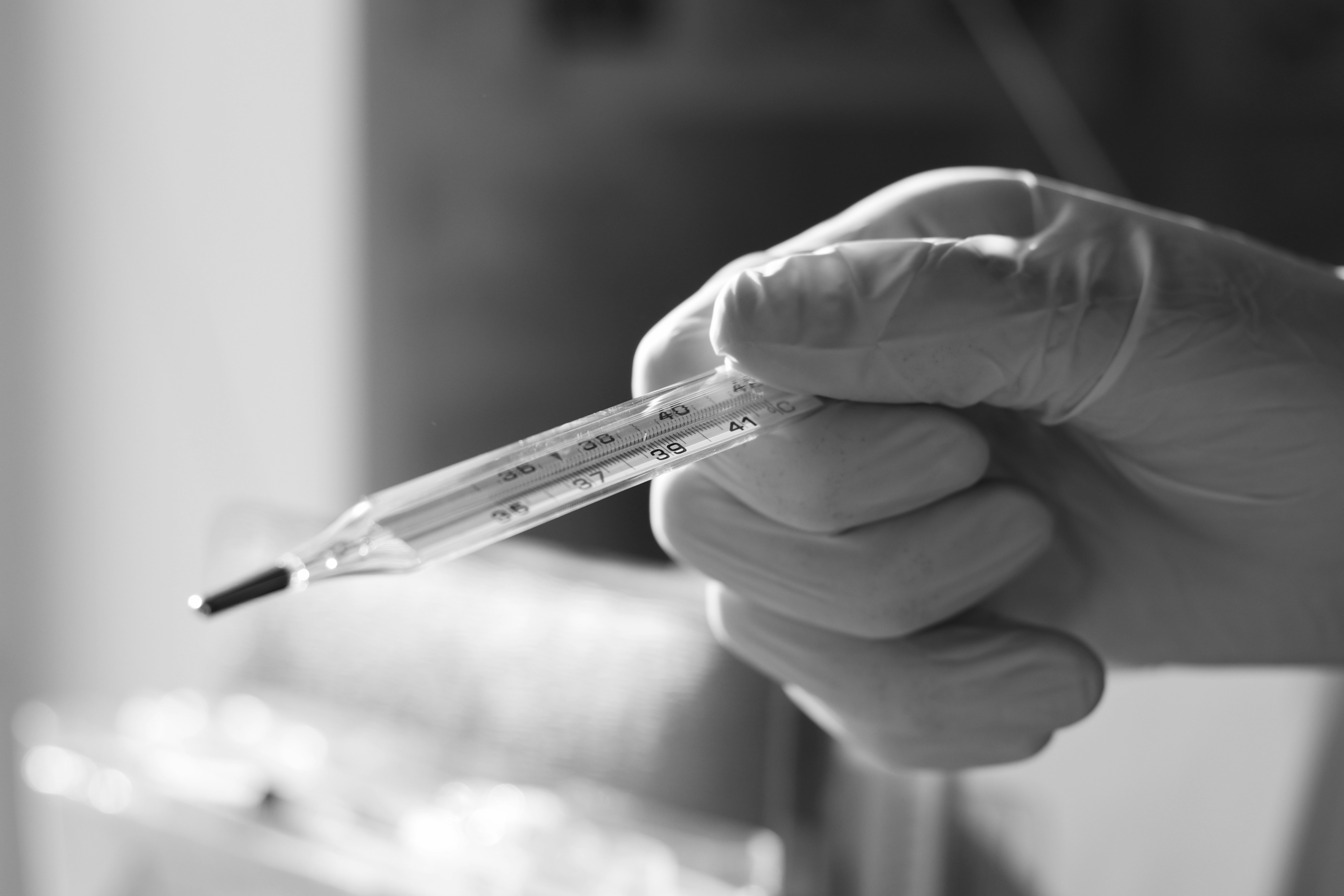 grayscale photo of person holding pen