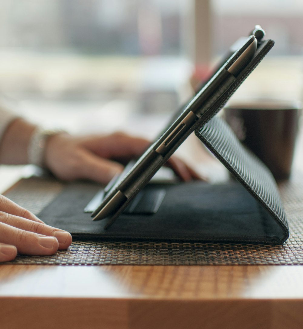 person writing on black notebook