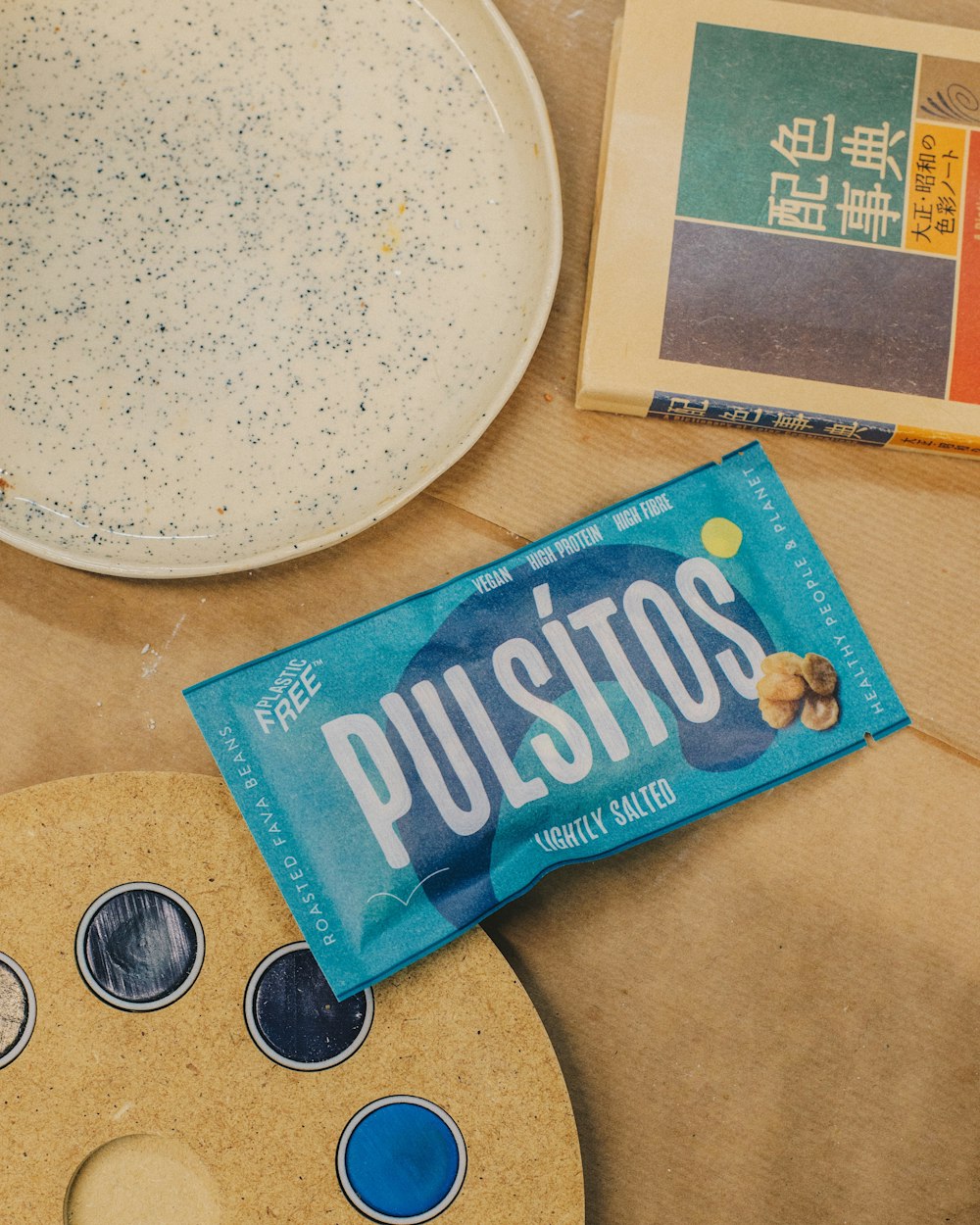 a bag of pusits next to a plate with a paintbrush