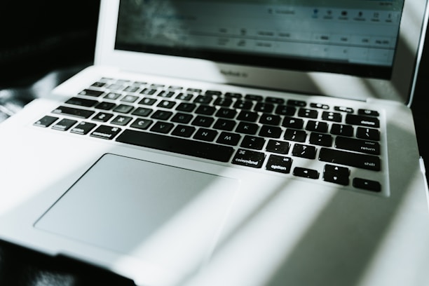 Close-up of a shiny HP notebook keyboard with soft natural light highlighting the keys.