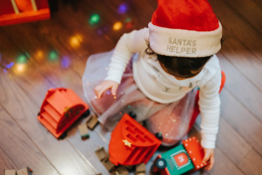 child in santa hat playing with lego blocks