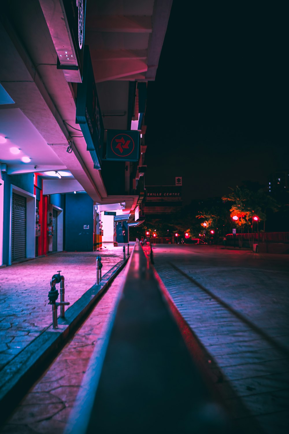 man in black jacket walking on sidewalk during night time