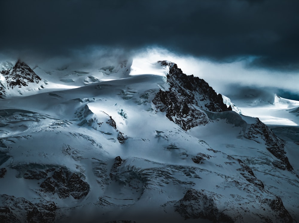 Schneebedeckter Berg tagsüber unter bewölktem Himmel