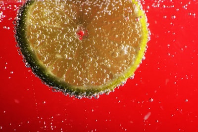 sliced lemon on red surface sparkling teams background