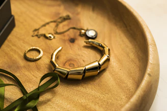 gold and green bracelet on brown textile