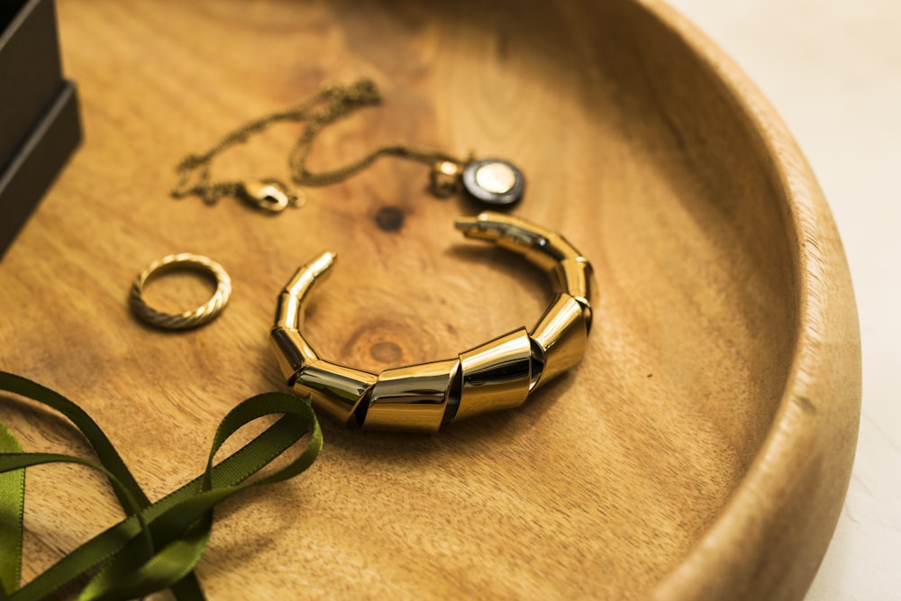 gold and green bracelet on brown textile