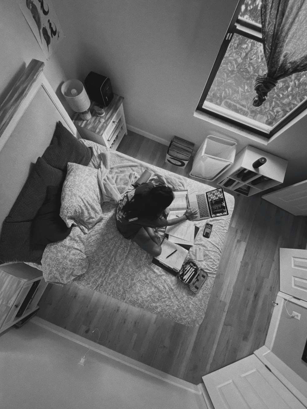 grayscale photo of woman lying on bed