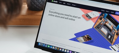 person using macbook pro on white table