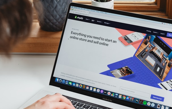 person using macbook pro on white table