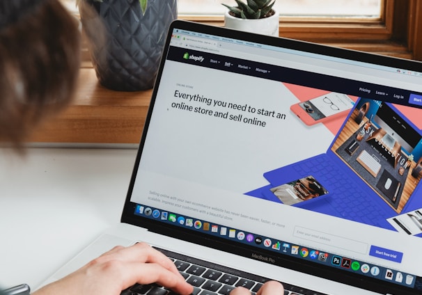 person using macbook pro on white table