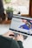 person using macbook pro on white table