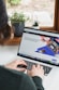person using macbook pro on white table