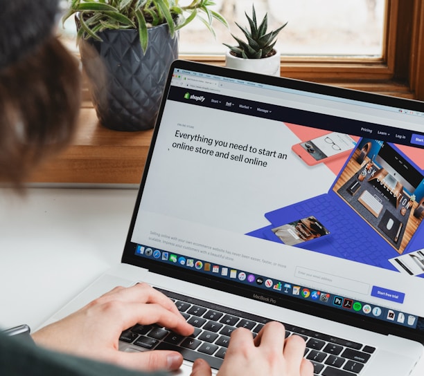 person using macbook pro on white table