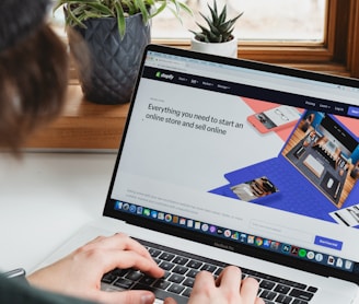 person using macbook pro on white table