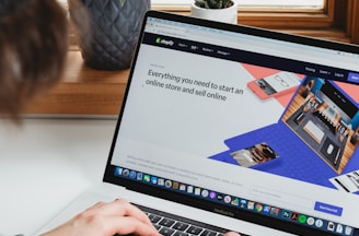 person using macbook pro on white table