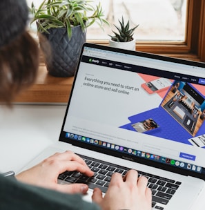 person using macbook pro on white table