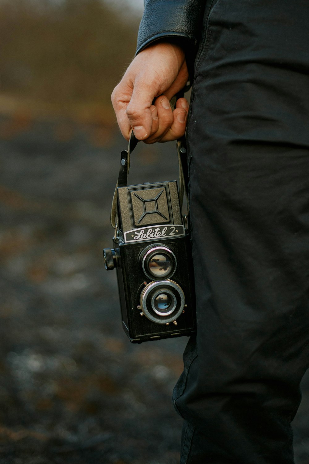 person holding black and silver camera