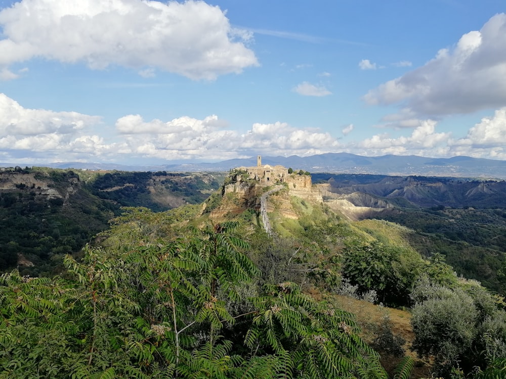 grama verde na montanha sob o céu azul durante o dia