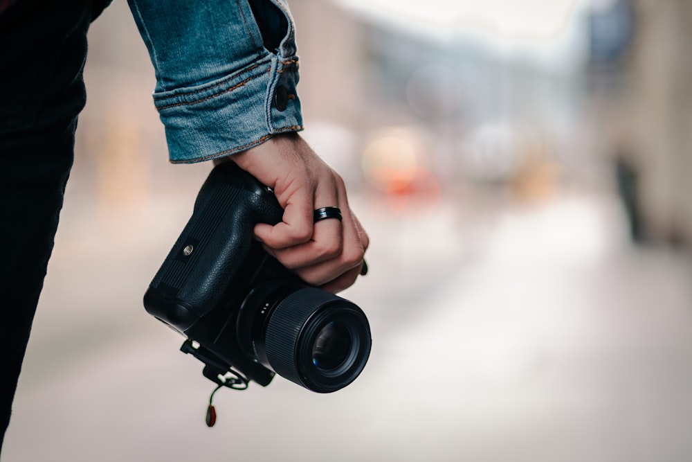 person holding black dslr camera