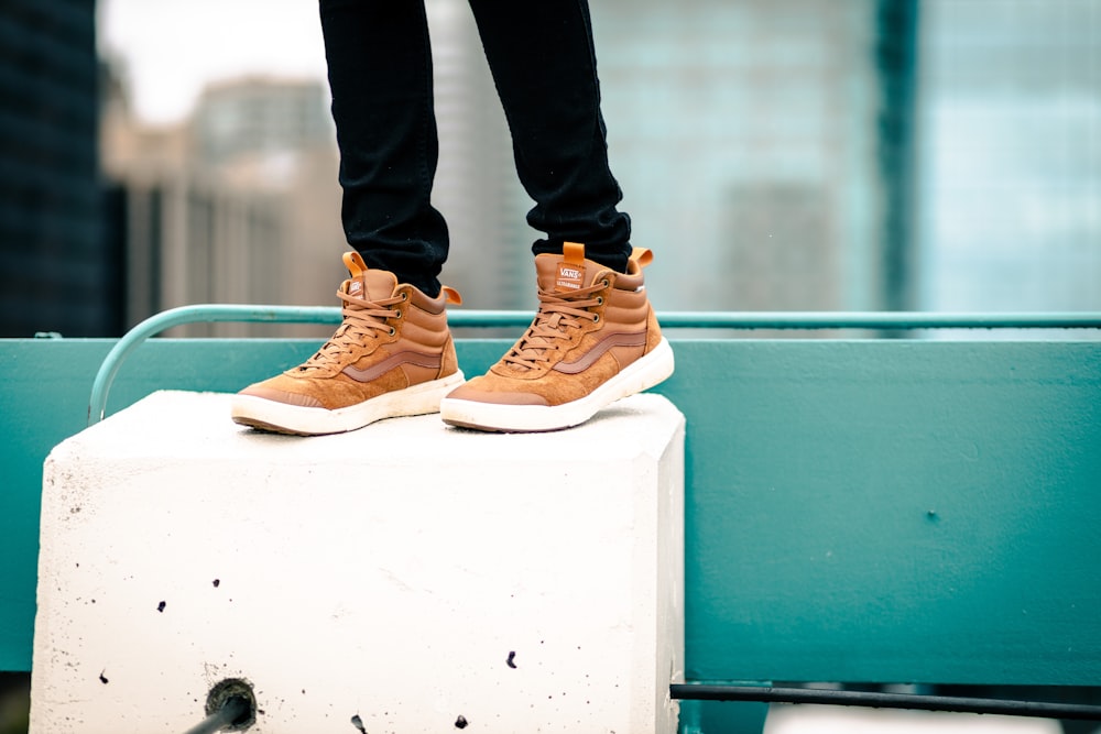 person in black pants wearing brown and white nike sneakers