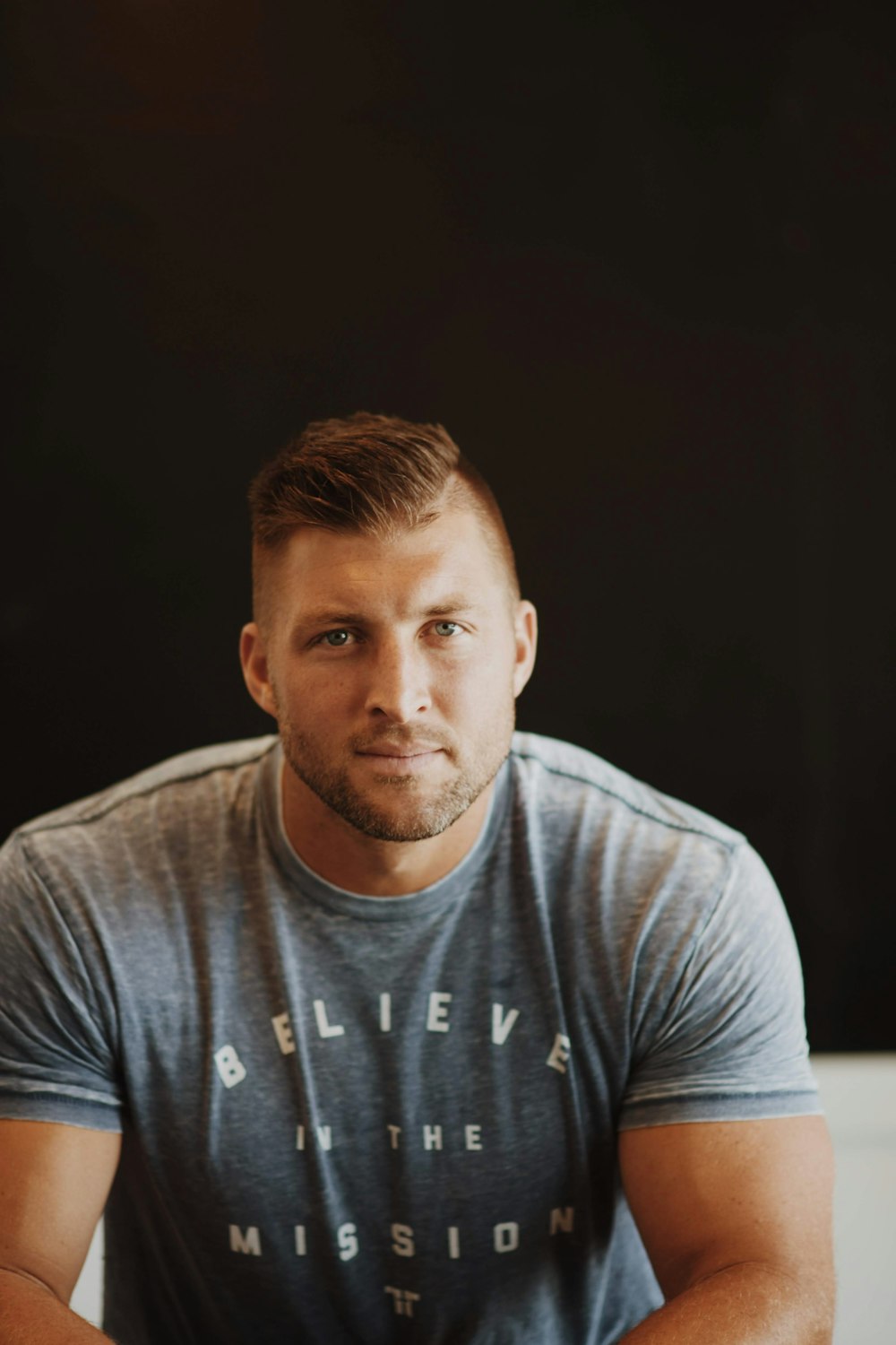 Tim Tebow in a gray crew neck t-shirt