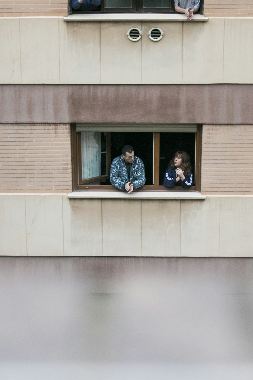 2 Frauen und Mann sitzen am Fenster