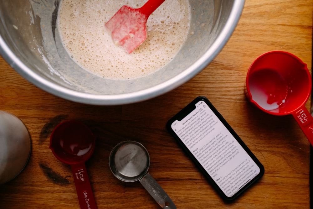 white powder in white ceramic bowl beside red handled spoon