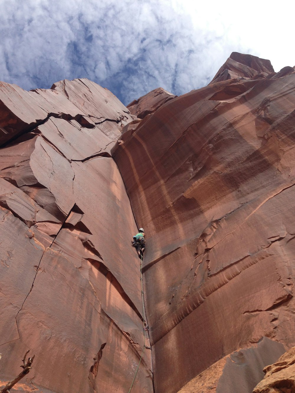 person climbing on brown rock mountain during daytime