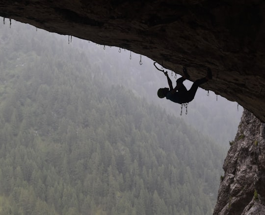 man in black jacket climbing mountain during daytime in Marmolada Glacier Italy