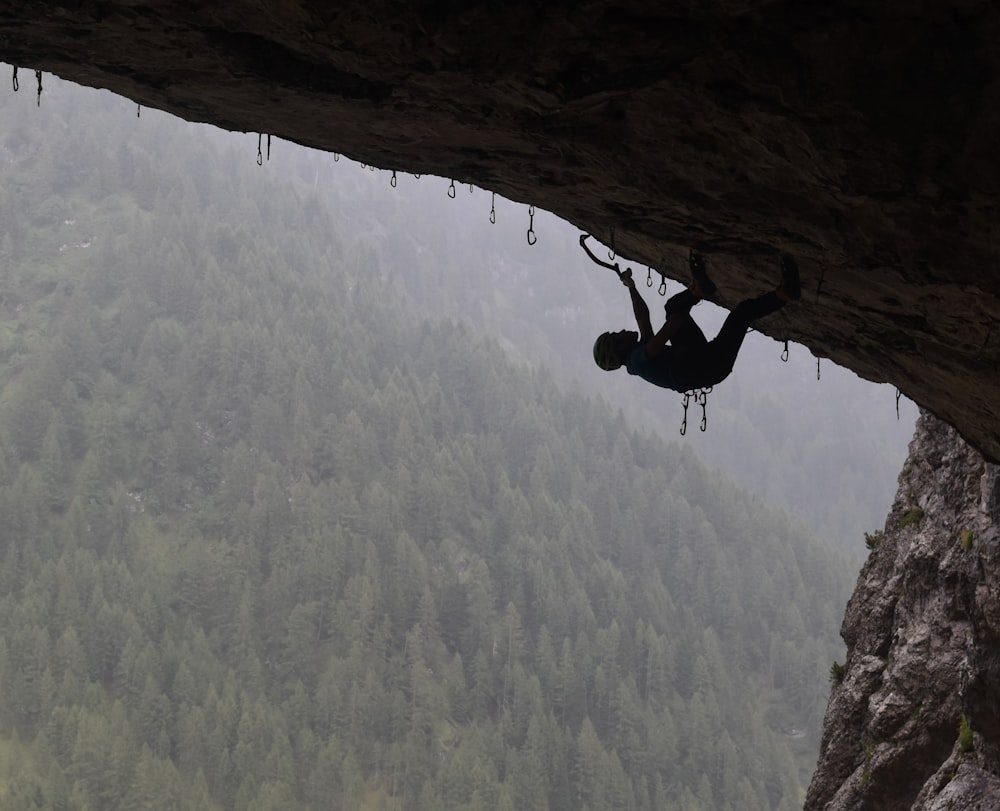 man in black jacket climbing mountain during daytime