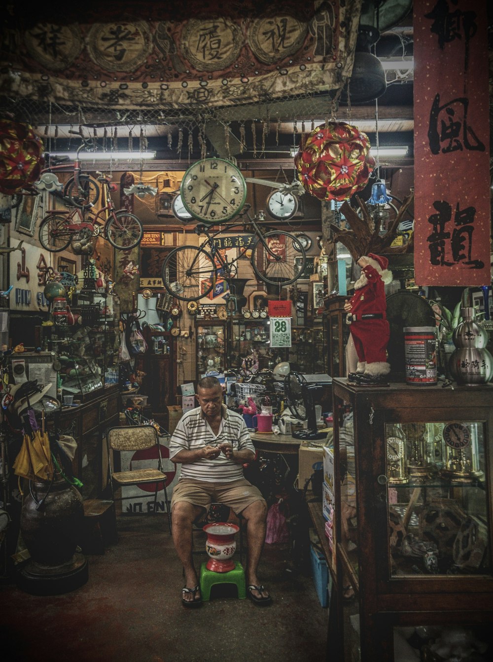 a man sitting in a room filled with clocks