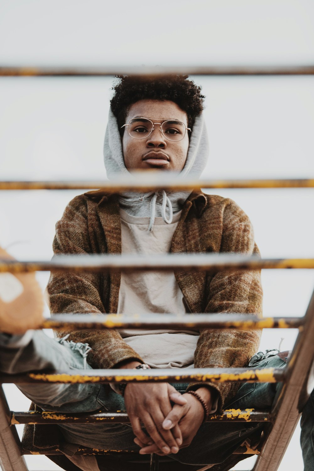 man in brown knit sweater sitting on chair