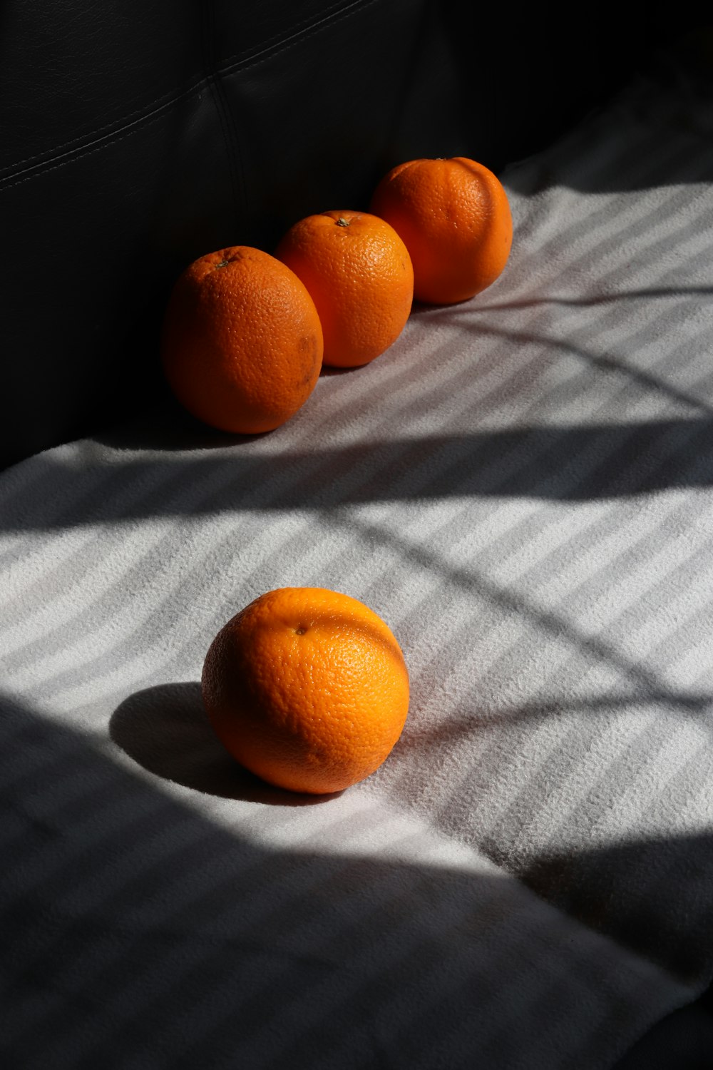 orange fruit on white and black stripe textile