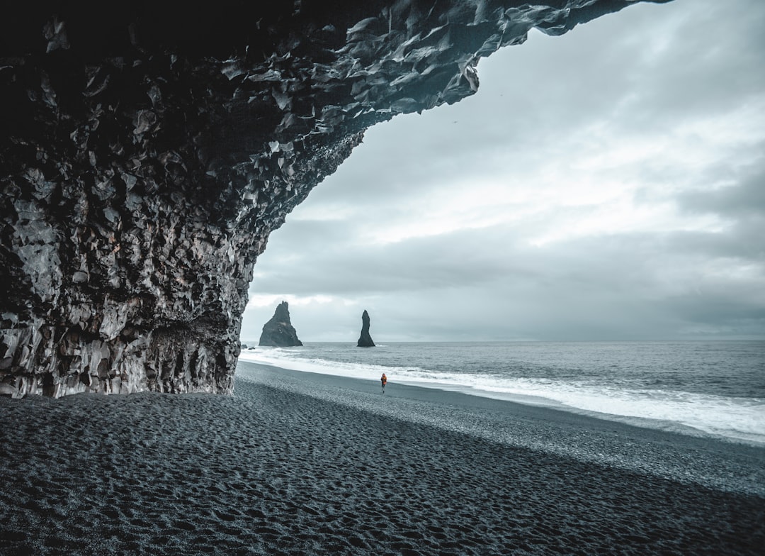 person in black shirt walking on beach during daytime