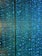 A visual display of numerous vertical strands of LED lights emitting a vibrant glow in shades of blue and green. The lights are densely arranged, creating an intricate and nearly hypnotic pattern with subtle reflections and refractions that enhance the immersive effect.