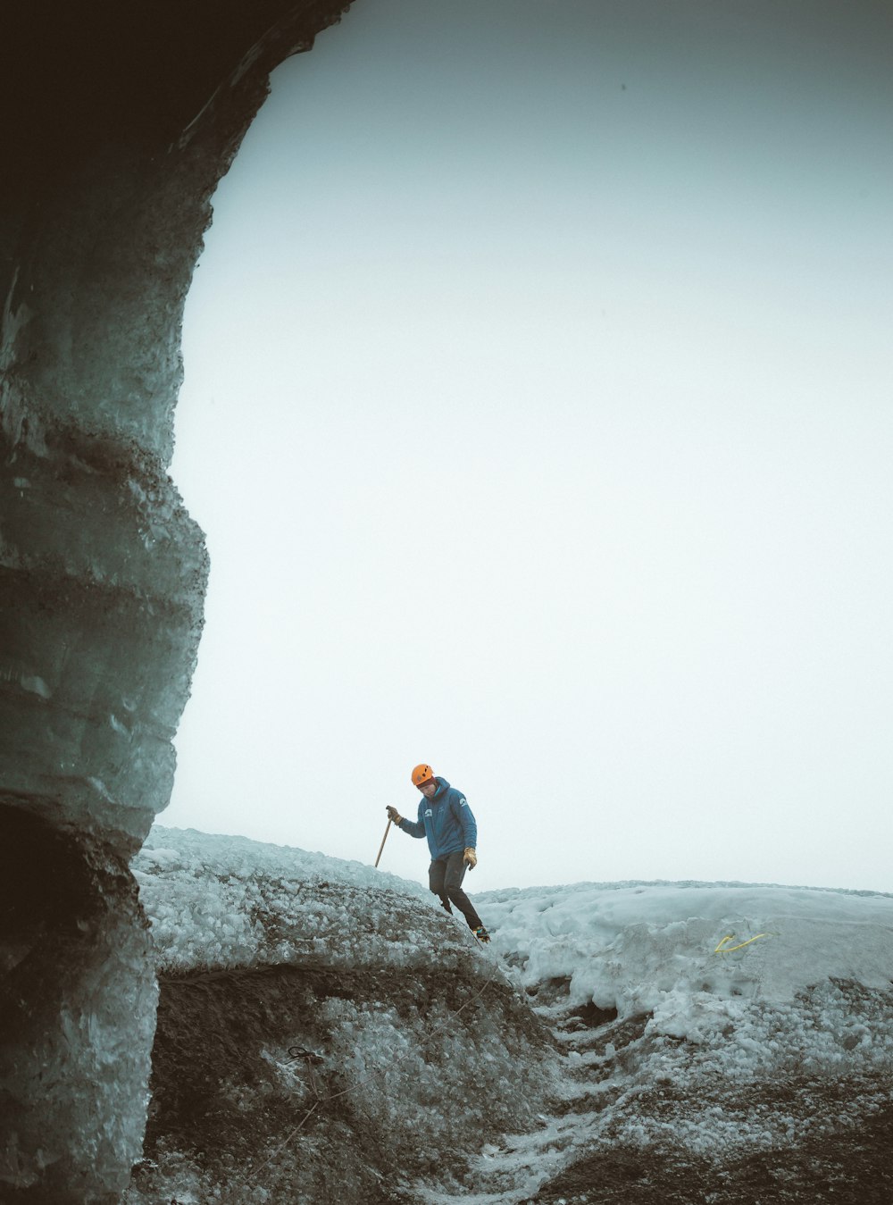Uomo in giacca blu e jeans blu in denim in piedi sulla formazione rocciosa durante il giorno