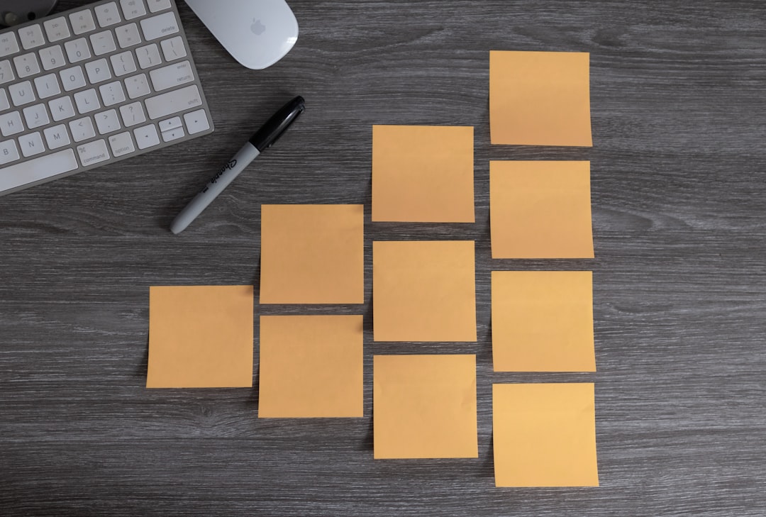 Group of blank sticky notes on a desk with a sharpie marker