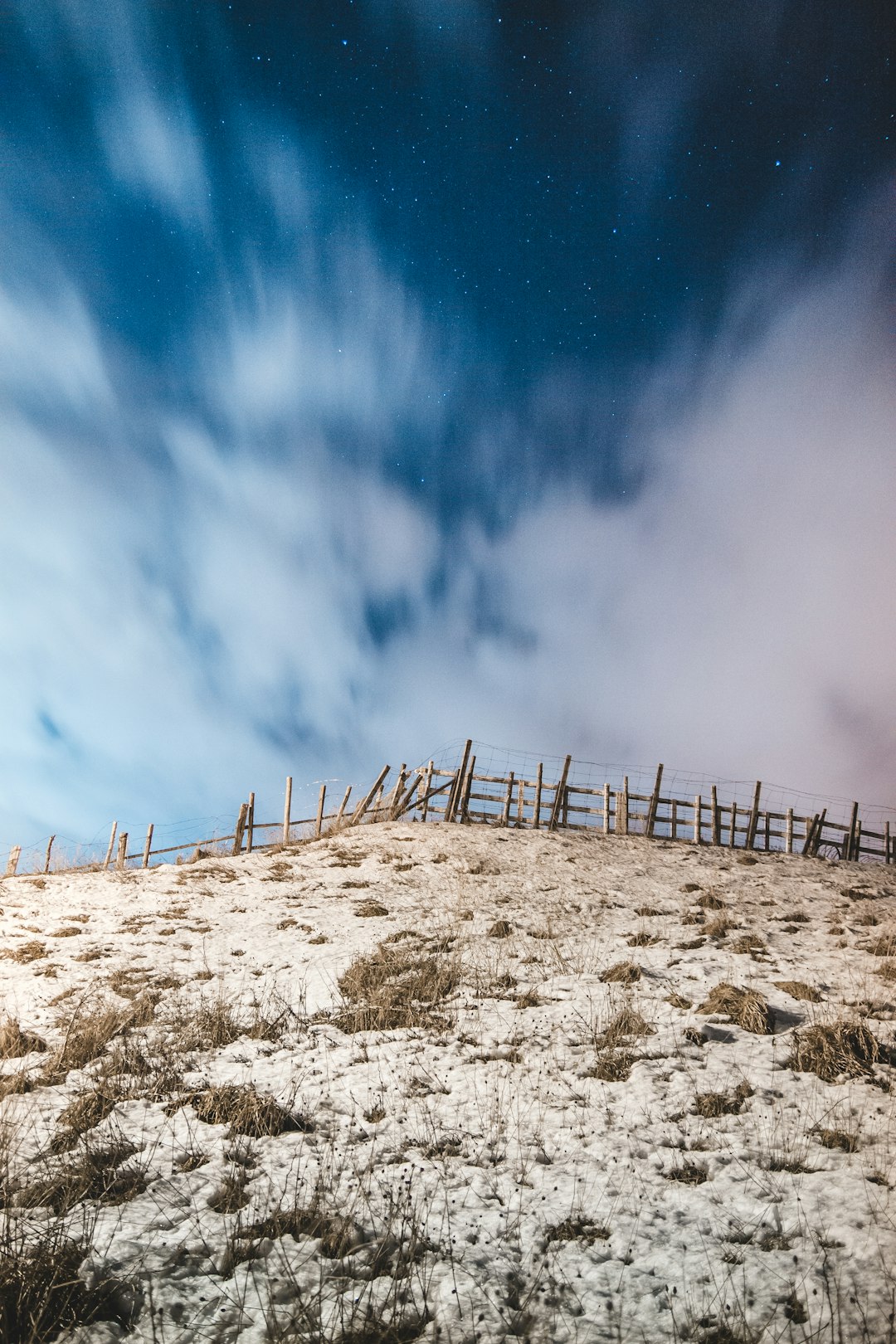 brown wooden fence on brown sand under blue sky during daytime