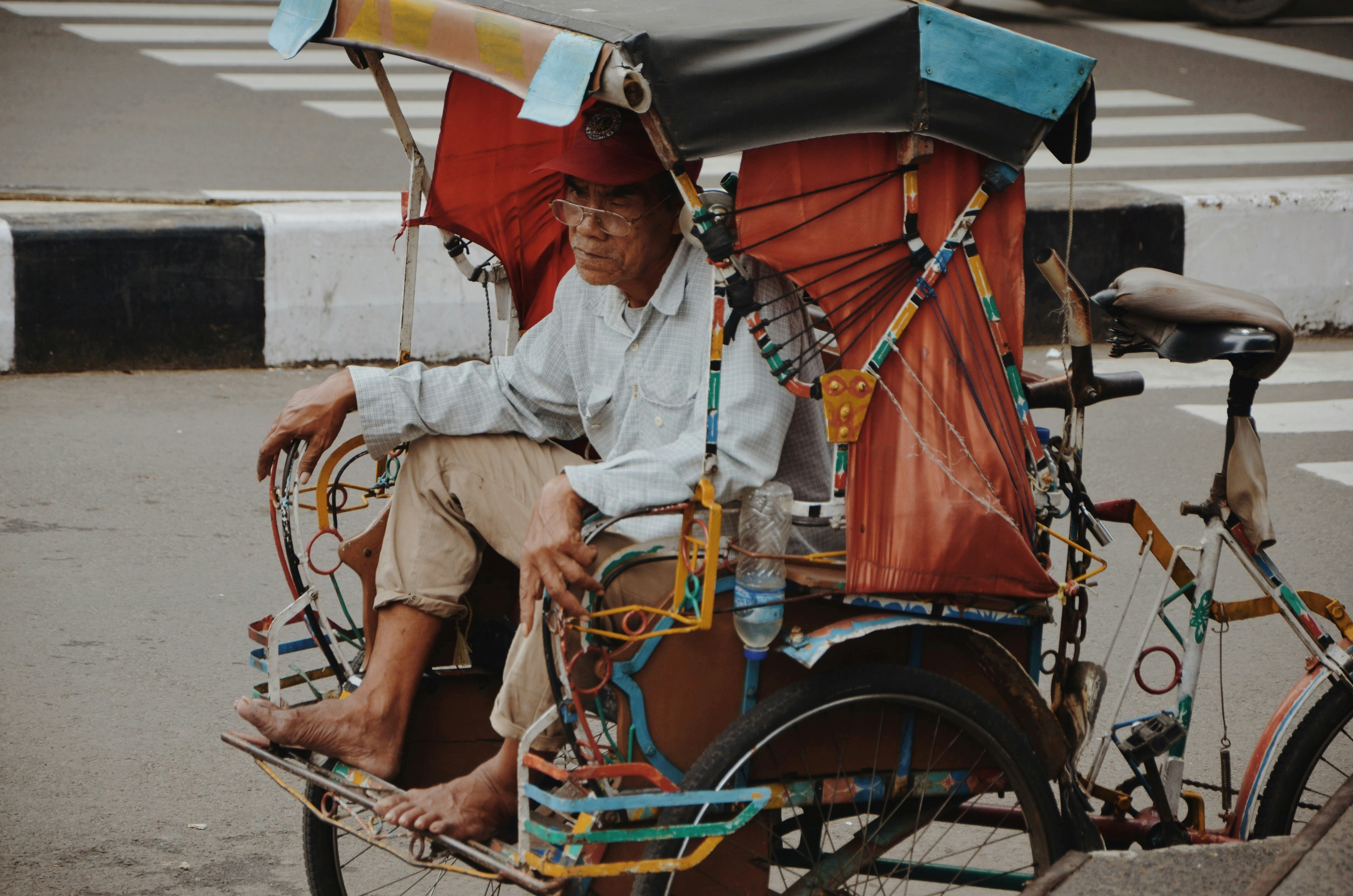 man in white button up shirt sitting on red and black trike