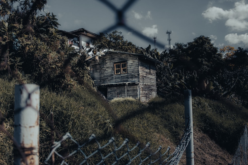 Casa de concreto marrom e branco perto de árvores verdes sob o céu azul durante o dia