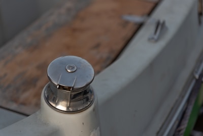 Close-up of a 3D printed boat cleat in marine blue on a wooden dock.
