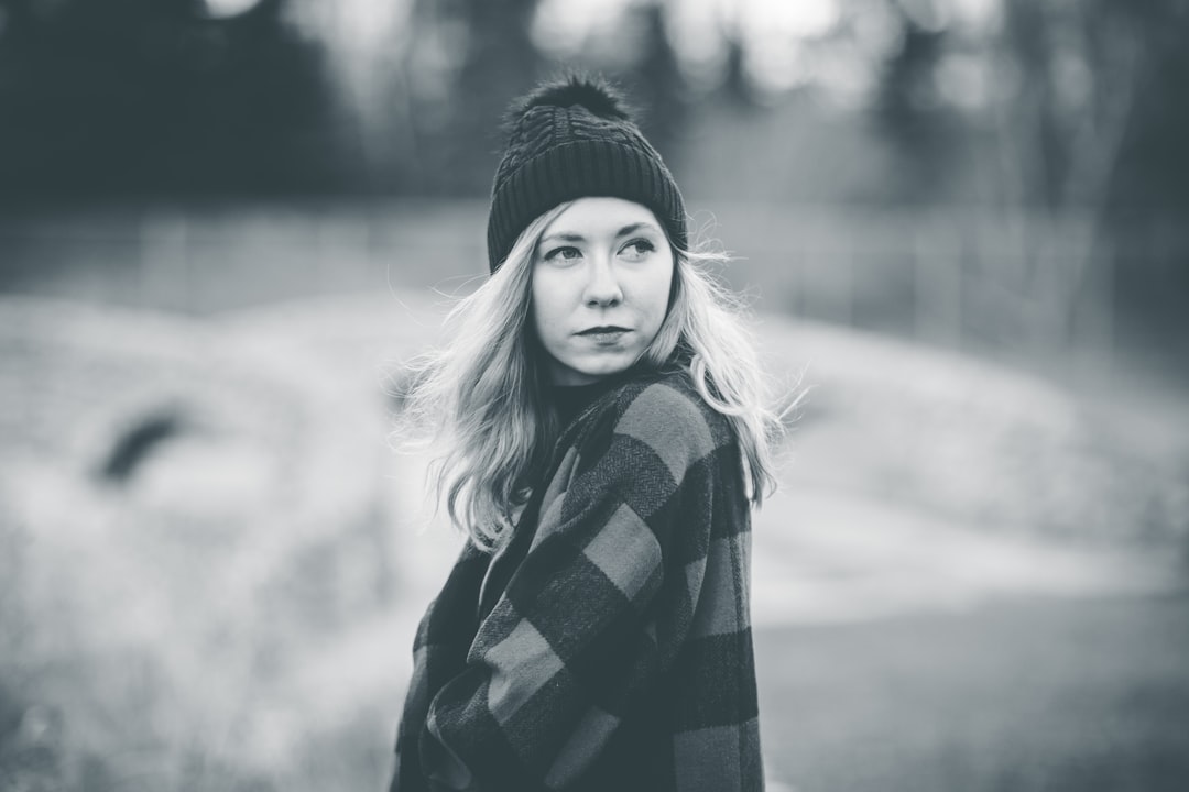 grayscale photo of woman in black and white checkered scarf