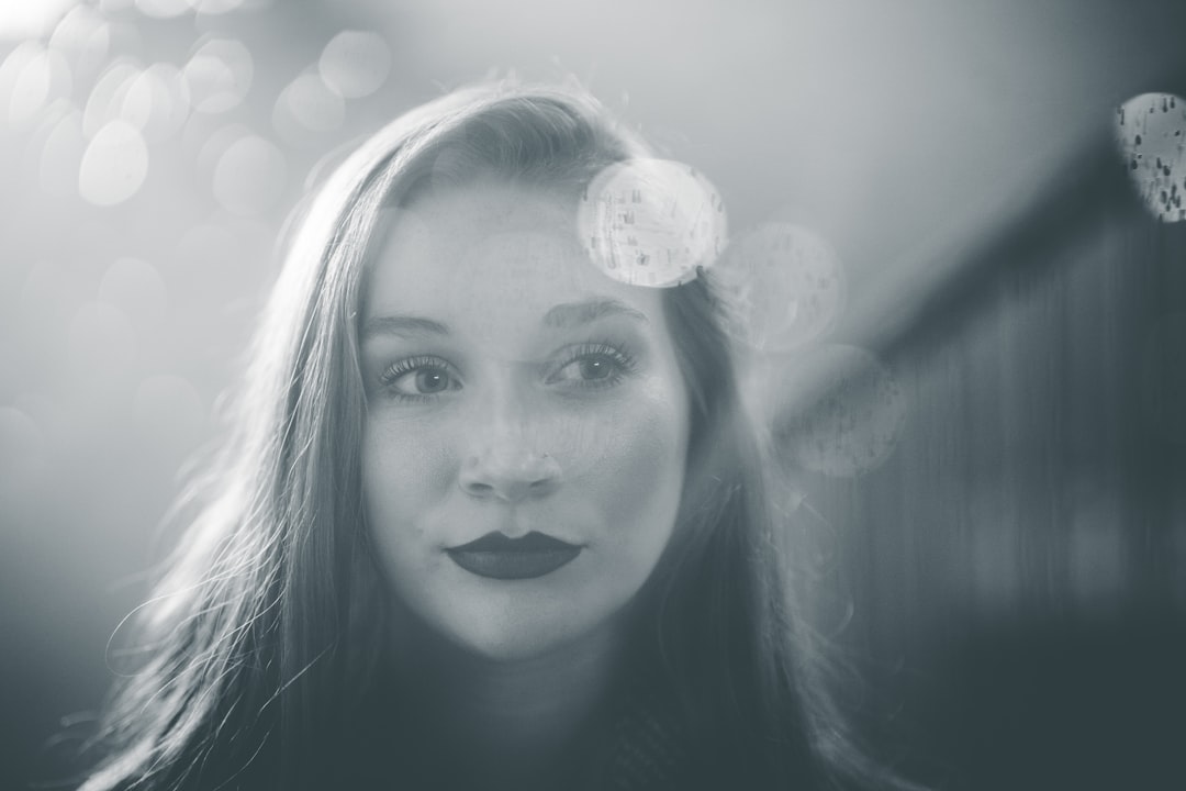 grayscale photo of woman with white light on her face