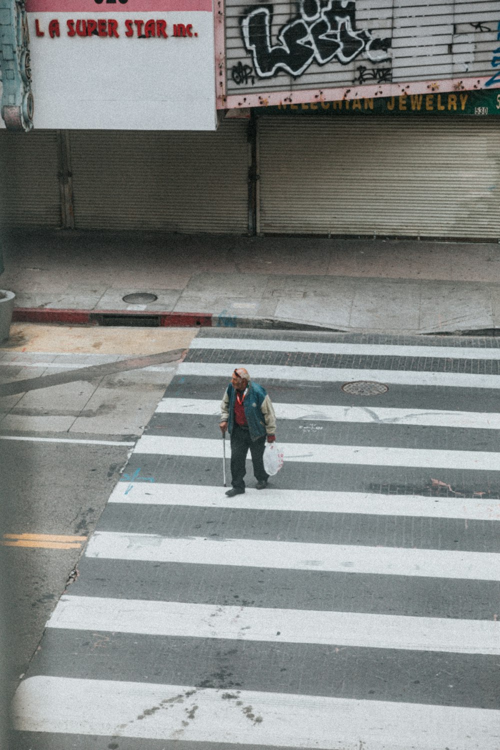 person in black jacket walking on pedestrian lane during daytime