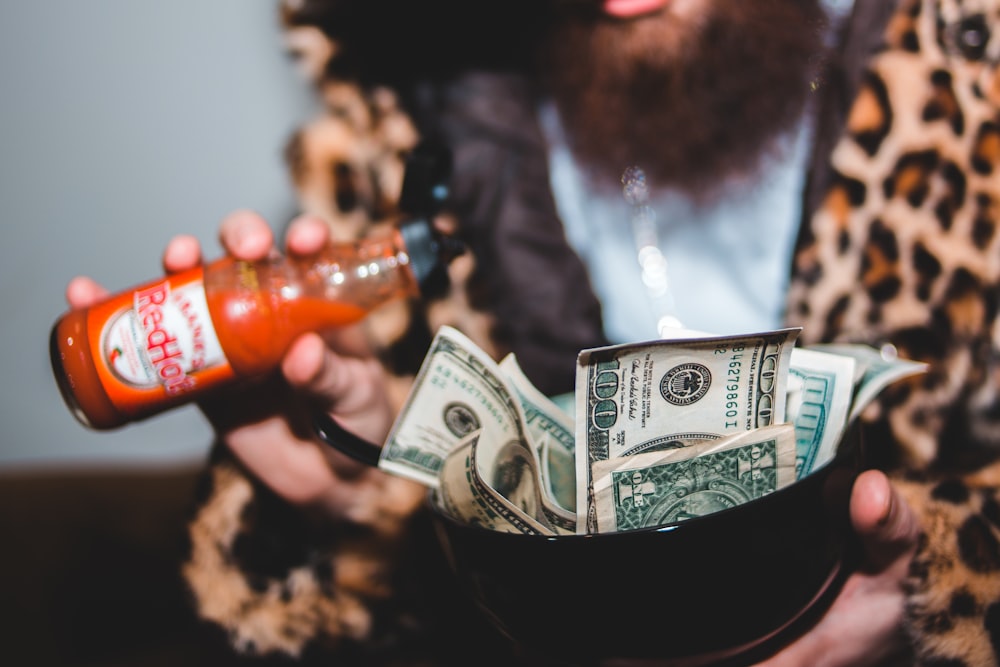 woman in black leather jacket holding 1 us dollar bill