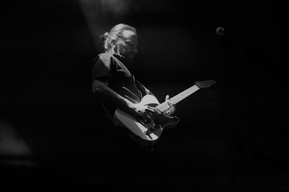 man playing guitar on stage