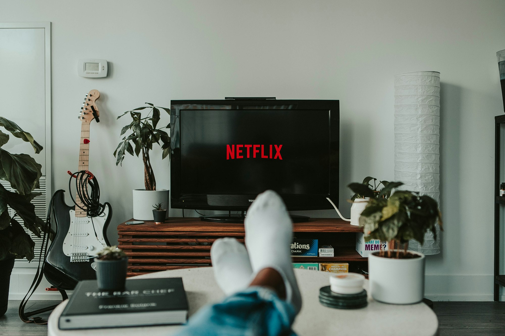 A person watches Netflix with their feet up on a coffee table