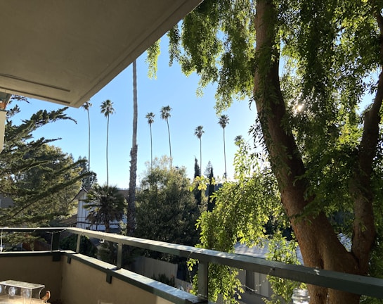 Balcony view overlooking a peaceful neighborhood with greenery.