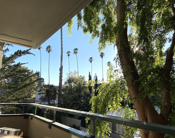Balcony view overlooking a peaceful neighborhood with greenery.